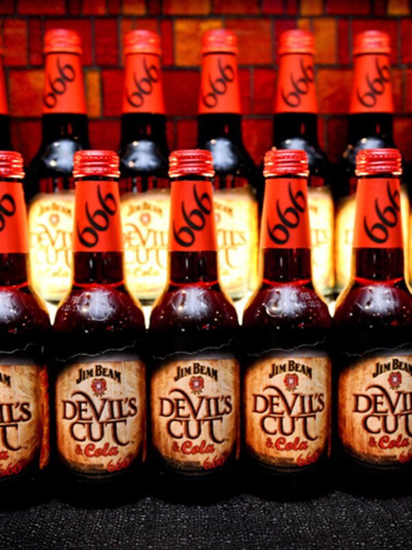 Wall of Devil's Cut bottles lit red at the launch